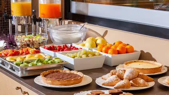 Café da manhã de hotel com frutas, pães e sucos