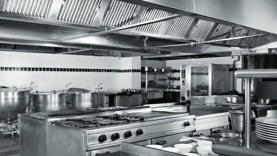 Cozinha industrial em aço inox com fogões e coifas